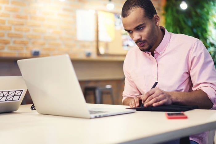 man building a website on a laptop