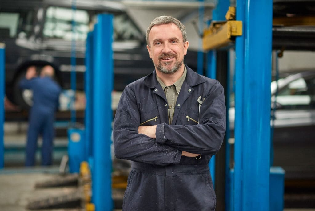 Auto-Repair-full-width Automotive Mechanic smiling